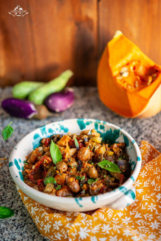 Caponata agrodolce preparata in Instant Pot con melanzane, zucca e olive verdi, servita su un piatto rustico.

